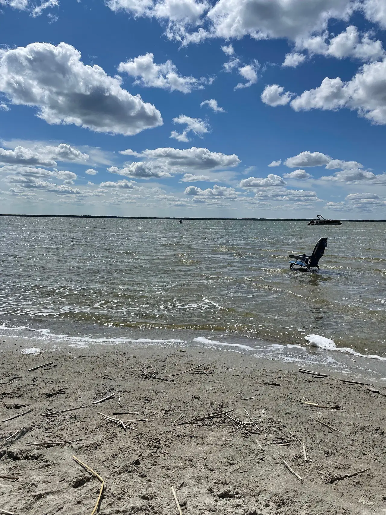 Sandy shore and folding chair on Good Spirit Lake, 2023