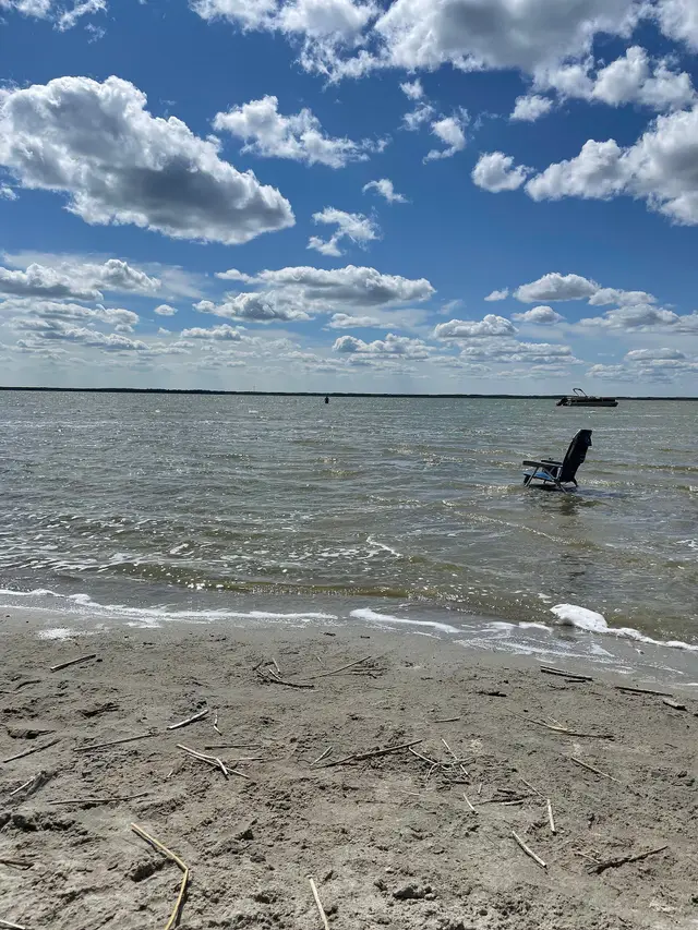 Sandy shore and folding chair on Good Spirit Lake
